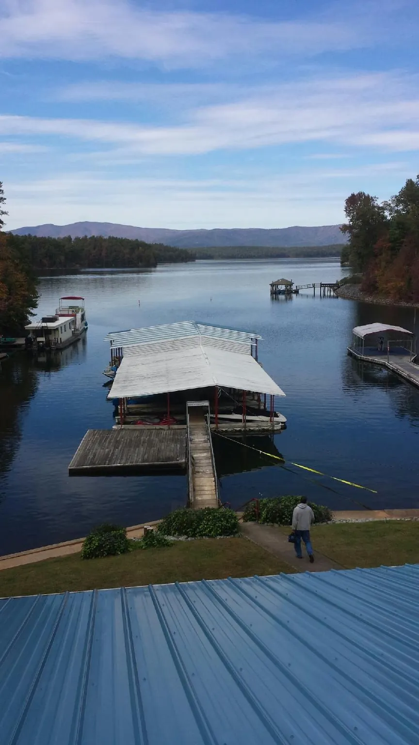 View across a lake from a newly installed blue metal roof in Morgan