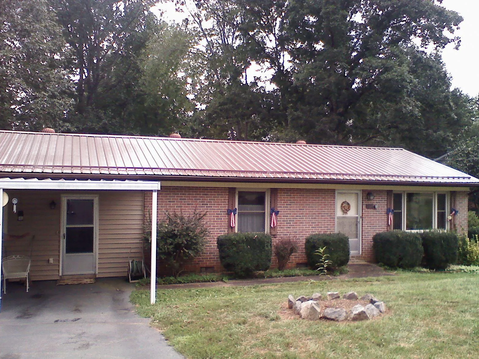 Bronze metal roof and carport on a brick ranch home — Roof Repair work by our crew in Morgan
