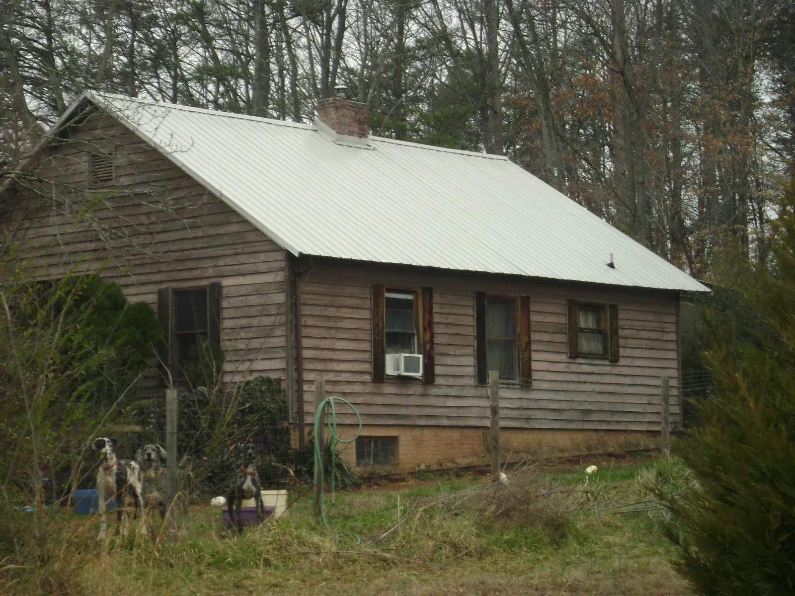 White metal roof on an old wood sided farmhouse, from a Metal Roof Installation job in Morgan
